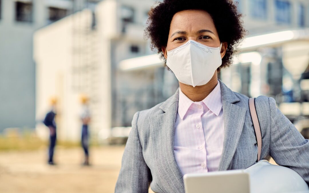 African American building contractor with protective face mask at construction site.